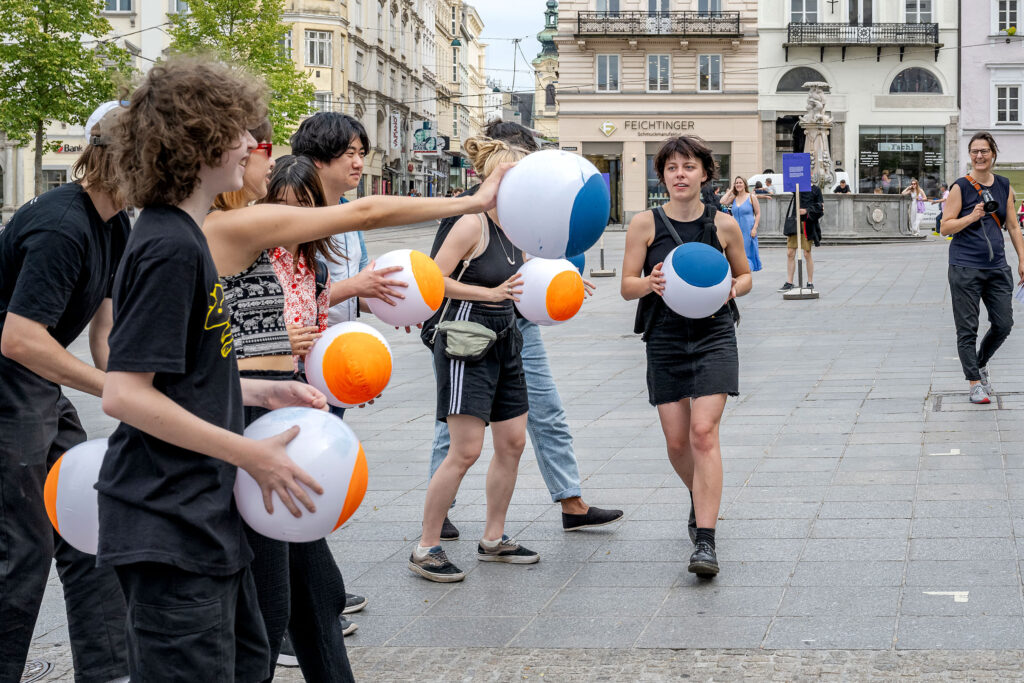 side view of 10 people holding painted beach balls to display the data