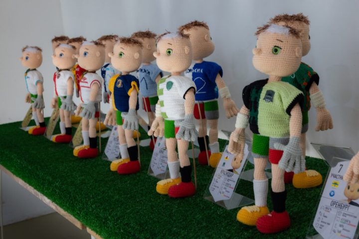 A series of crocheted football players, in various uniforms representing personalized statistics.