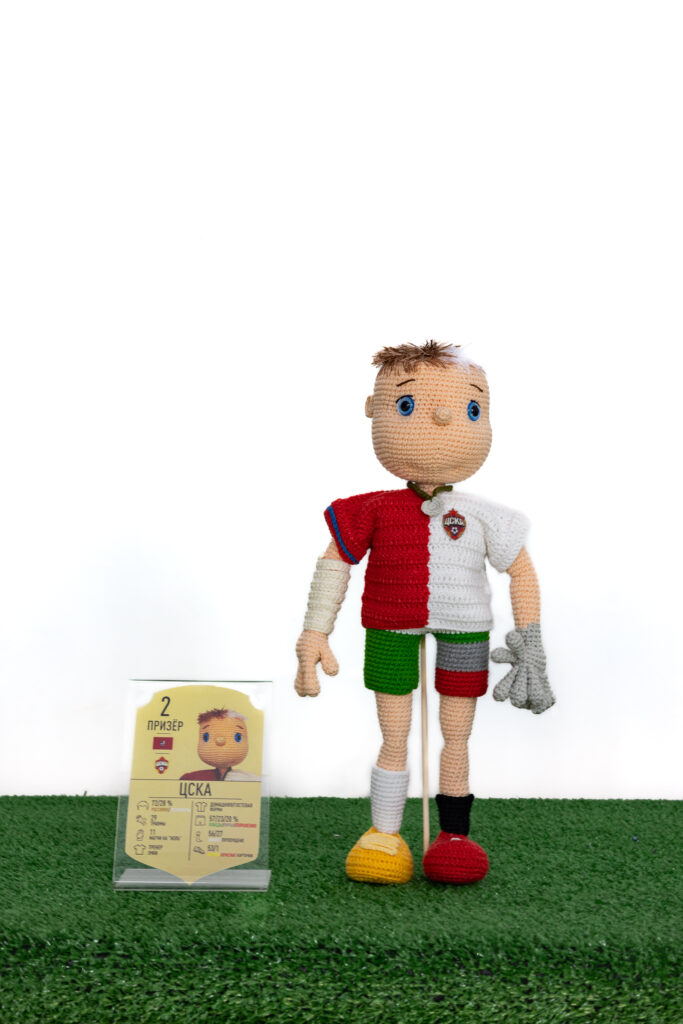 A crocheted football player, in a uniform representing personalized statistics.