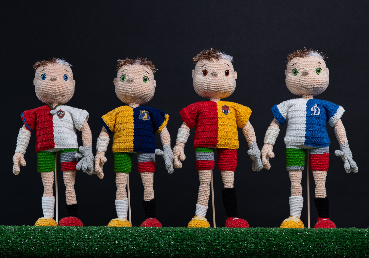 A series of crocheted football players, in various uniforms representing personalized statistics.