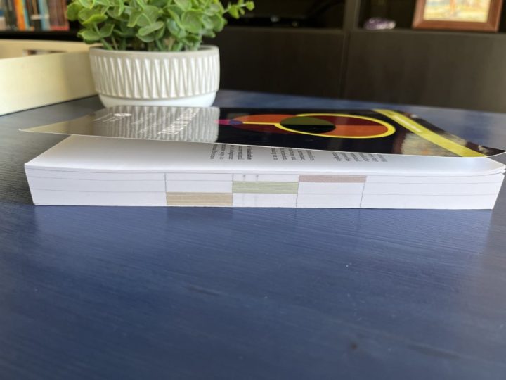 The page edges of the book Questions in Dataviz by Neil Richards have a colored tab to show which of the three sections of the book they belong to. This forms a visualization on the edges of the book, showing that section 1 is the shortest and section 3 is the longest. 