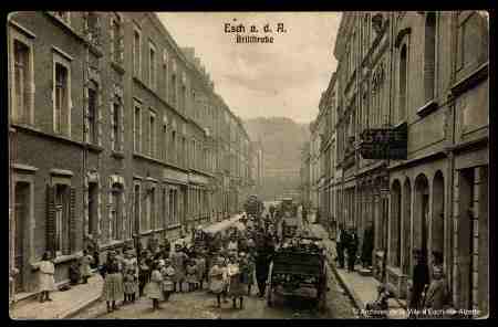 old sepia toned photograph of a crowded Brill Street filled with people, a cart, and tall buildings on either side