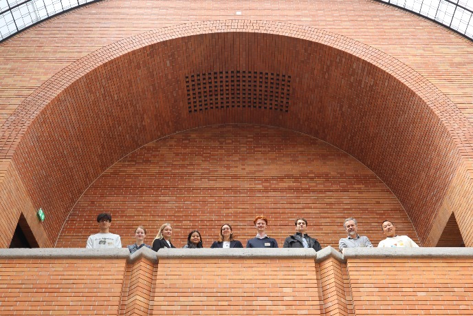 A photo of Dario Rodighiero with students who attended the conference. All are on a balcony, looking down at the photographer.