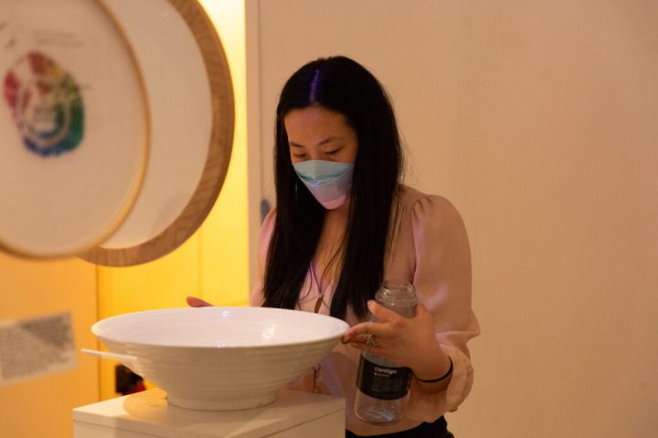 A photo of Shirley Wu positioning a white bowl on a pedestal.